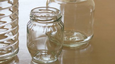 Şeffaf cam saklama kavanozlarında ve reçel kavanozlarında ışık parlıyor.