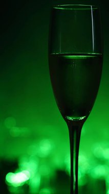 Şampanya köpüklerinin dikey yakın plan görüntüleri, yeşil gece görüntüsü.