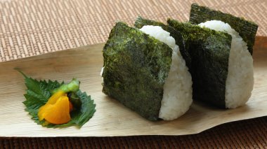 Japon geleneksel beslenme çantası, üçgen pirinç topları, deniz yosunu ve turşulu bambu derisine sarılmış tuz.