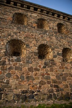 Güneş ışığı altında antik bir binanın duvarının dikey görüntüsü.