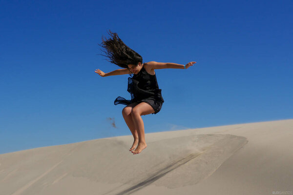 Girl jumping on the sands