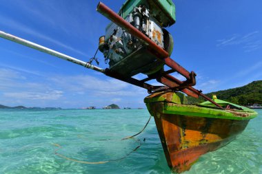 Parlak gün ışığında plaja yakın yüzen renkli uzun kuyruk teknesi. Uzun kuyruklu tekneler Tayland turizminde ada arasındaki kısa mesafe geçişlerinde çok popülerdir..