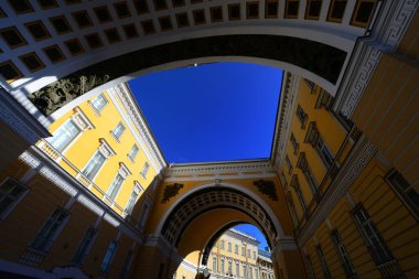 St. Petersburg Kış Sarayı Meydanı 'ndaki binanın güzel yayı parlak gün ışığında koyu mavi gökyüzü ile sarı bir kontrastla boyandı..