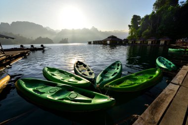 Güzel bir sabah, Tayland 'ın Ratchaprapha Barajı gölünün yakınındaki küçük bir tatil köyünde kanolar sessizce dalgalanıyor.