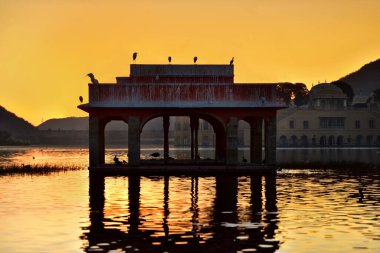 Sabahleyin Man sagar gölünün ve onun su sarayının (Jal Mahal) ihtişamı. Senery göldeki güzel antik sarayı ve etrafta uçuşan kuşu gösteriyor..