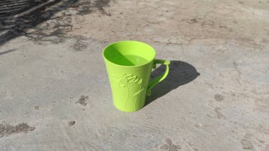 Yerde yeşil camlar ve camlarda çiçek süsleri var.