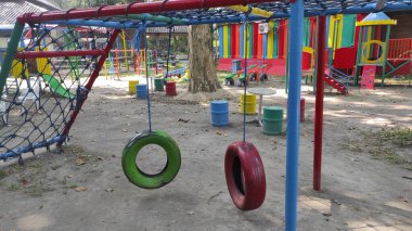 Renkli bir çocuk parkında kullanılmış lastiklerden yapılmış büyük çocukların salıncak oyuncakları.