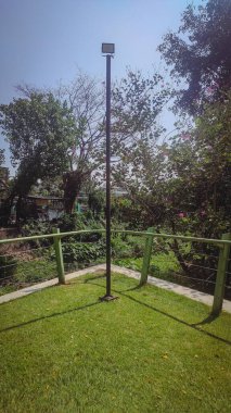 Bahçenin çimenli bir köşesi ve demir bir çit.