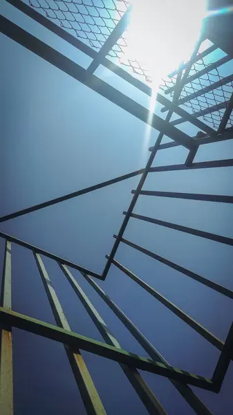 Mimari binaların demirciliğiyle kaplanmış açık mavi bir gökyüzü manzarası.