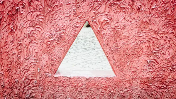 Duvarın benzersiz bir kırmızı deseni ve üçgen havalandırması var.