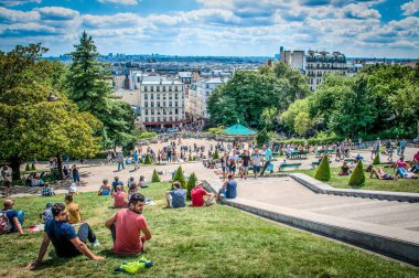 İnsanlar Paris 'teki Central Park' ta yaz gününün tadını çıkarıyorlar.
