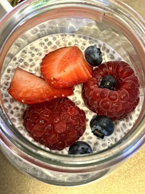 Ahududu, çilek ve yabanmersiniyle süslenmiş chia tohumlu yoğurt.