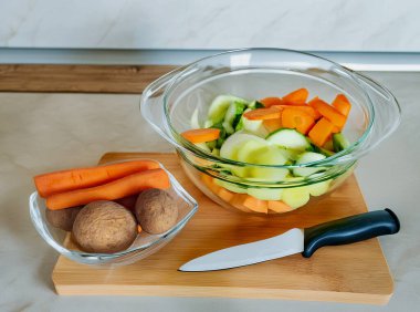 Salata için hazırlanmış şeffaf cam bir tabakta sebzeler.