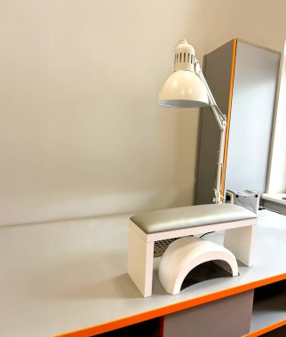 Lambalı, el dinlenmeli ve jel cilasını kurutmak için LED lambalı modern bir manikürcünün işyeri. Bir güzellik stüdyosunun minimalist iç mekanı..