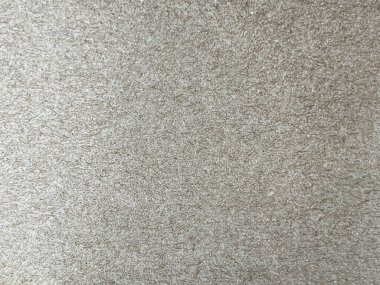 Yüksek çözünürlüklü, geri dönüşümlü kahverengi karton lifli bir yüzeye yakın çekim. Doku görülebilir doğal lifleri ve küçük renkli lekeleri içeriyor, organik, çevre dostu bir görünüm yaratıyor.. 