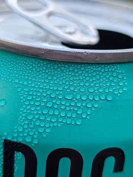 Beyaz arka planda damlaları olan yeşil bira kutusu