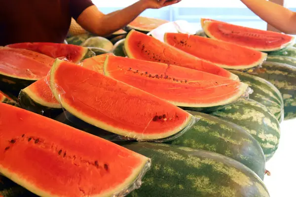 karpuzlar ve karpuzlar bir markette, bir kaç dilim olgun karpuz ile. Yiyecek, tarım veya yaz temalı projeler için idealdir, mevsimlik meyvelerin tazeliğini yakalar. Yüksek kalite fotoğraf