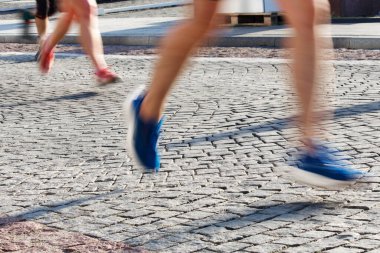 2024 'te Vilnius sokaklarında sabah ışığında maraton koşucularının bacakları ve ayakları hareket bulanıklığı. Yüksek kalite fotoğraf