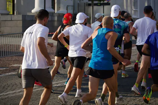 Şehir maratonuna katılanlar, 2024 yılının Eylül ayında Litvanya 'nın Vilnius kentinin sokaklarında arkalarından koşarken görülüyor. Yüksek kalite fotoğraf