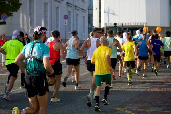 Şehir maratonuna katılanlar, 2024 yılının Eylül ayında Litvanya 'nın Vilnius kentinin sokaklarında arkalarından koşarken görülüyor. Yüksek kalite fotoğraf