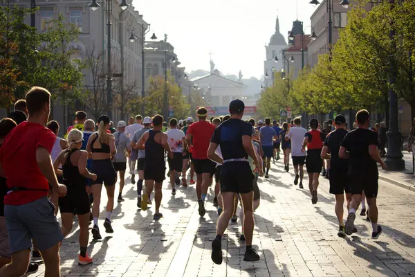 Şehir maratonuna katılanlar, 2024 yılının Eylül ayında Litvanya 'nın Vilnius kentinin sokaklarında arkalarından koşarken görülüyor. Yüksek kalite fotoğraf