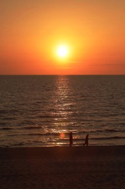 Güneş ufukta batıyor. Baltık Denizi 'nin sakin dalgaları boyunca gün batımının altın parıltısını saçıyor. Yüksek kalite fotoğraf