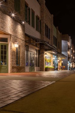 Geceleri sokak lambaları olan tuğla dükkanları.