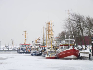 Almanya, Buesum. Alman Kuzey Denizi kıyısındaki Buesum limanında donmuş deniz ve balıkçı teknesiyle kış manzarası. 22 Aralık 2010