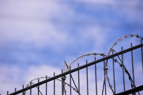 Mavi gökyüzüne karşı dikenli tel