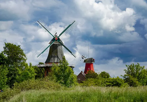 stock image Germany, Greetsiel, East Frisia. Landmark twin windmills at the entrance to Greetsiel May 30, 2022