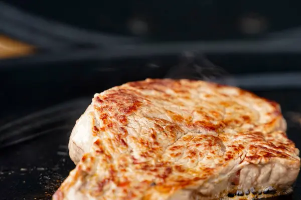 Siyah dökme demir bir plancha üzerinde biftek.