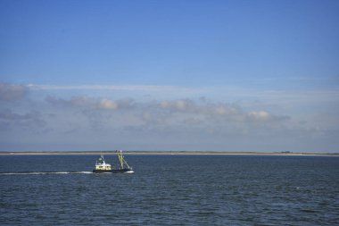 Den Helder, Hollanda. 31 Temmuz 2024. Kuzey Denizi 'nde Hollanda Kuzey Denizi adası manzaralı bir balıkçı teknesi.