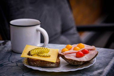 Peynirli sandviç, jambon, domates ve salatalık turşusu.