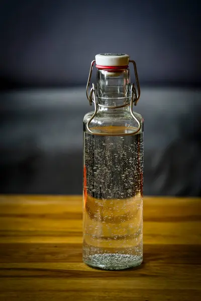 stock image Bottle of sparkling water on a table in a room without people