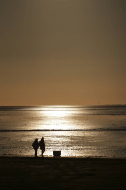 Norddeich, Doğu Frizya, Almanya. Doğu Frizya 'daki Alman Wadden Denizi' nde Norddeich gezinti güvertesi DAS DECK 'de gün batımında Alman Kuzey Denizi' nde. 4 Ekim 2024