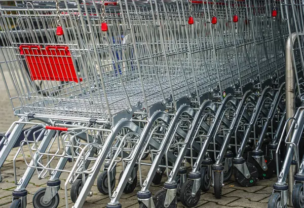 Bir süpermarketin önünde arka arkaya boş alışveriş arabaları.