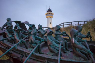 Egmond aan Zee , North Holland, Netherlands. Architecture . Landmark of Egmond aan Zee. Van Speijk lighthouse at dusk with sculptur of Louk van Meurs.Tribute to the North and South Holland Rescue Society. November 9th, 2024 clipart