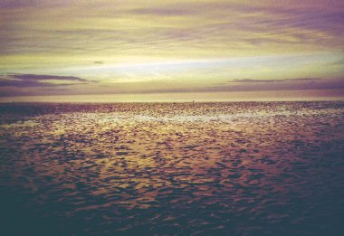 Norddeich, Doğu Frizya, Almanya. Kuzey Denizi kıyısında gün batımı. 35 mm 'lik bir filmde analog retro görünüm fotoğraflandı. 9 Ekim 2024