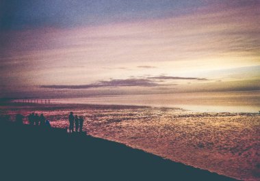 Norddeich, Doğu Frizya, Almanya. Kuzey Denizi kıyısında gün batımı. 35 mm 'lik bir filmde analog retro görünüm fotoğraflandı. 9 Ekim 2024