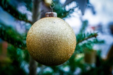 Süslü bir Noel ağacının üzerinde süslemeli altın bir Noel mücevheri