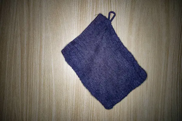 Mavi çamaşır eldiveni kahverengi tahta panelde izole edilmiş.