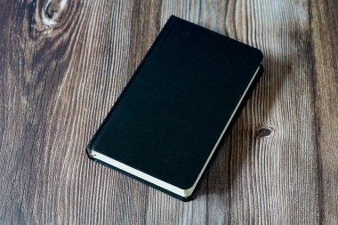 Siyah bir kitabın boş kapağı metin alanlı ahşap arkaplan ile taklit