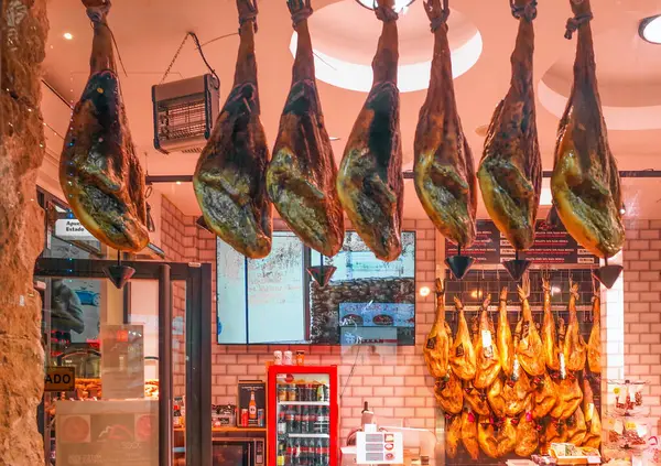 Malaga, Endülüs, Costa de Sol, İspanya. Bir mağazanın vitrininde jambon bacakları. 7 Mart 2025