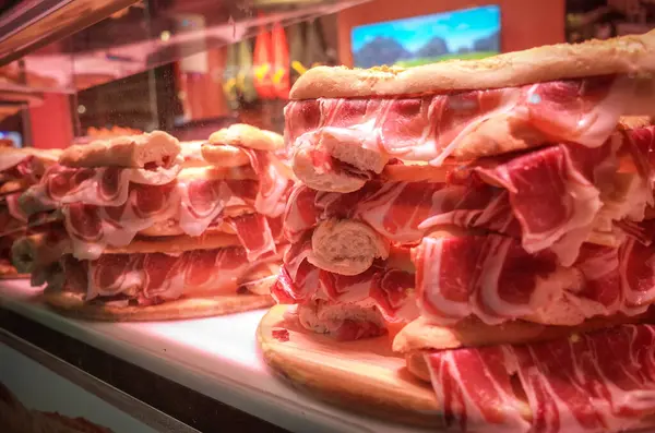 Malaga, Endülüs, Costa de Sol, İspanya. Yayaların olduğu bölgede vitrinde jambonlu sandviçler. 10 Mart 2025