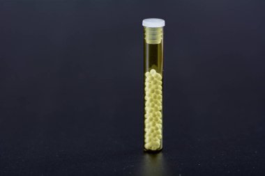 Şeffaf cam tüplerde homeopatik hapların fotoğrafı.