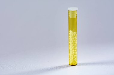 Şeffaf cam tüplerde homeopatik hapların fotoğrafı.
