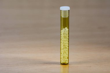 Şeffaf cam tüplerde homeopatik hapların fotoğrafı.
