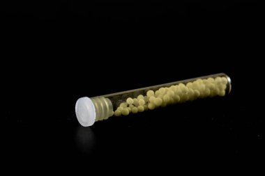 Şeffaf cam tüplerde homeopatik hapların fotoğrafı.