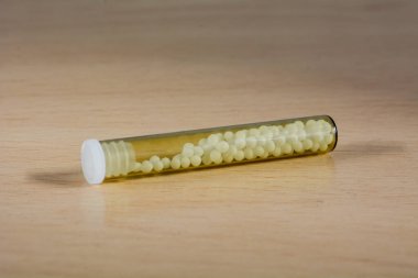 Şeffaf cam tüplerde homeopatik hapların fotoğrafı.