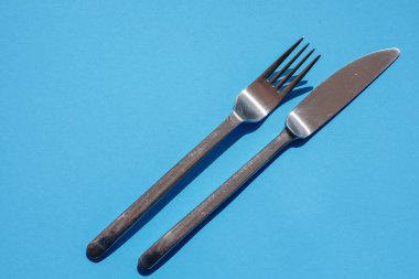 Bıçak ve çataldan oluşan mutfak çatalı. Mavi üzerine izole edilmiş.